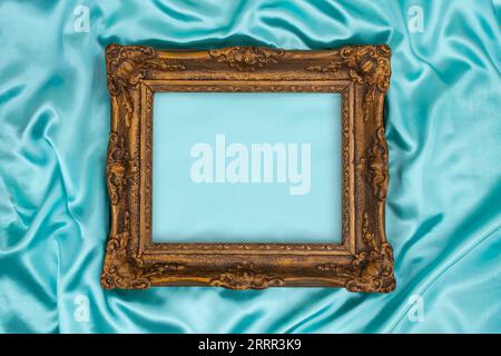 Beau cadre doré décoré classique sur bleu, satin soyeux turquoise. Fond turquoise de luxe avec espace de copie flou pour la conception. Elément Web s Banque D'Images