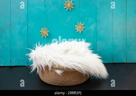 Toile de fond de photographie de portrait de nouveau-né ou de bébé avec fourrure blanche, flocons de neige de paille, panier de corde de jute et planches de bois peintes en bleu Banque D'Images