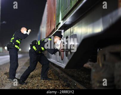 230501 -- COL d'Alataw, le 1 mai 2023 -- Cui Hongwu R et son collègue inspectent un train au cours d'une patrouille au col d'Alataw, dans la région autonome ouïgoure du Xinjiang, au nord-ouest de la Chine, le 4 avril 2023. Alataw Pass est un port terrestre majeur à la frontière sino-kazakhe dans la région autonome ouïgoure du Xinjiang au nord-ouest de la Chine. CUI Hongwu, un fonctionnaire de la station d'inspection frontalière du port, travaille depuis plus de 10 ans. Ici, il a rencontré sa femme Liu Xin, qui est sa collègue et travaille comme maître-chien de police. Au cours des dernières années, le col d'Alataw a vu un nombre croissant et une fréquence croissante d'entrées et de sorties Banque D'Images