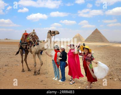 230502 -- PÉKIN, le 2 mai 2023 -- des touristes chinois posent pour des photos avec un chameau en visitant le site pittoresque des pyramides de Gizeh à Gizeh, en Égypte, le 28 avril 2023. Xinhua Headlines : ressusciter les touristes chinois sortants une aubaine pour le tourisme mondial AhmedxGomaa PUBLICATIONxNOTxINxCHN Banque D'Images