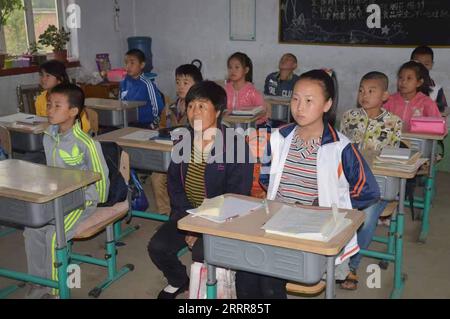 230513 -- HULUDAO, le 13 mai 2023 -- cette photo de dossier non datée montre Zhang Lianqin et Li Xinwei fréquentant une classe dans une école primaire de la ville de Xingcheng, dans la province du Liaoning au nord-est de la Chine. Zhang Lianqin, 55 ans, mère de Li Xinwei, vit dans le village de Liangjiatun, dans le canton de Hongyazi, dans la ville de Xingcheng. Comme sa fille Li souffre d'une déficience auditive, Zhang a accompagné Li dans ses études à l'école depuis qu'elle a été inscrite à l'école primaire, avec à peine une classe manquée. Zhang s'est assise près de sa fille pour agir en tant qu'oreilles de Li dans la salle de classe. La vie de Zhang et de sa famille n'est pas aisée. Ils vivent moi Banque D'Images