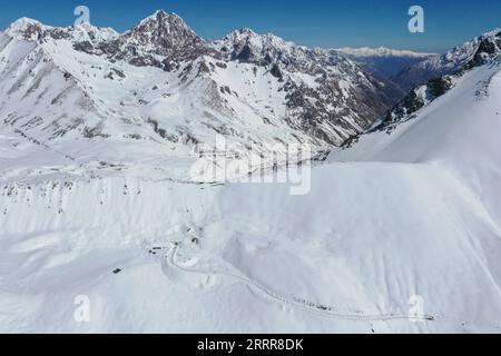 230514 -- KUYTUN, le 14 mai 2023 -- cette photo aérienne prise le 10 mai 2023 montre l'autoroute Dushanzi-Kuqa serpentant devant des montagnes de haute altitude couvertes de neige dans la région autonome ouïgoure du Xinjiang du nord-ouest de la Chine. L autoroute Dushanzi-Kuqa, qui traverse la montagne Tianshan, est considérée comme l une des plus belles routes de Chine. En raison de la neige et du givrage de la route, la route a une période d'hibernation , qui commence généralement en octobre et se termine en juin de l'année suivante. La maintenance est en cours pendant son hibernation annuelle. CHINA-XINJIANG-DUSHANZI-KUQA HIGHWAY-SCENERY CN HUXHUHU PUBLICATIONXNOTX Banque D'Images