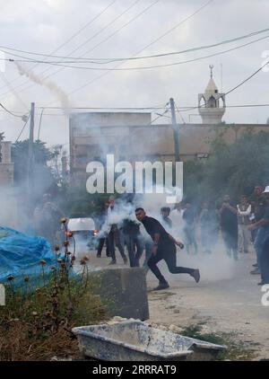 230519 -- KUFR QADOOM, le 19 mai 2023 -- Un manifestant palestinien jette une cartouche de gaz lacrymogène tirée par un soldat israélien lors d'affrontements à la suite d'une manifestation contre l'expansion des colonies juives dans le village de Kufr Qadoom, en Cisjordanie, près de Naplouse, le 19 mai 2023. Photo de /Xinhua MIDEAST-KUFR QADOOM-CLASHS NidalxEshtayeh PUBLICATIONxNOTxINxCHN Banque D'Images