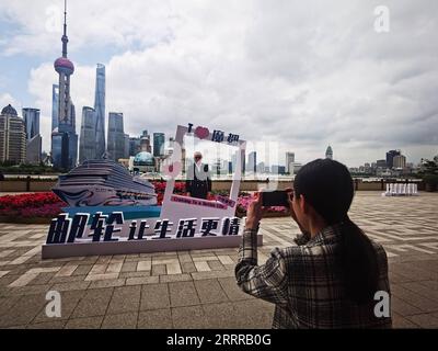 230520 -- SHANGHAI, le 20 mai 2023 -- Un homme pose pour la photo par une décoration sur le thème de la ville magique d'Adora le long de la rivière Huangpu à Shanghai, dans l'est de la Chine, le 19 mai 2023. POUR ALLER AVEC la Chine dévoile le nom du premier grand navire de croisière construit au pays CHINE-SHANGHAI-GRAND NAVIRE DE CROISIÈRE CONSTRUIT AU PAYS CN ChenxAiping PUBLICATIONxNOTxINxCHN Banque D'Images