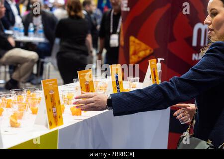 230523 -- CHICAGO, le 23 mai 2023 -- un participant prend un échantillon à un stand à l'exposition Sweets and snacks à Chicago, aux États-Unis, le 23 mai 2023. Le salon des sucreries et des collations 2023 se tient au McCormick place à Chicago du 22 au 25 mai. Photo de /Xinhua U.S.-CHICAGO-BONBONS ET COLLATIONS EXPO VincentxD.xJohnson PUBLICATIONxNOTxINxCHN Banque D'Images