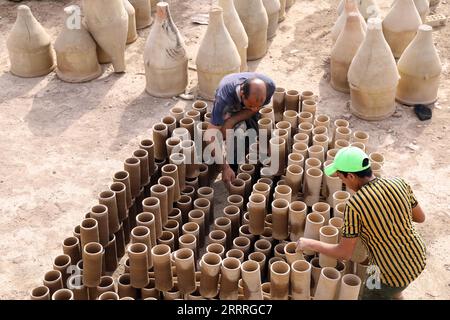 230528 -- BAGDAD, le 28 mai 2023 -- Safaa al-Kawaz L, propriétaire d'un atelier de poterie, organise des faïences avec un assistant dans la région de Nahrawan près de Bagdad, en Irak, le 27 mai 2023. La poterie en Irak a été une profession durable qui est profondément enracinée dans les civilisations de la Mésopotamie. IRAK-BAGDAD-POTERIE KhalilxDawood PUBLICATIONxNOTxINxCHN Banque D'Images