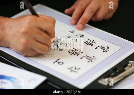 230530 -- SÉOUL, le 30 mai 2023 -- Un participant fait l'expérience de la calligraphie lors de l'événement de la Journée du SDC du Secrétariat de la coopération trilatérale à Séoul, Corée du Sud, le 30 mai 2023. Le TCS est un organisme international basé à Séoul qui vise à promouvoir la paix et la prospérité commune entre la Chine, le Japon et la Corée du Sud. Diverses activités ont été organisées mardi par le TCS pour commémorer le 13e anniversaire de la signature d’un accord sur sa création. CORÉE DU SUD-SÉOUL-TCS DAY WangxYiliang PUBLICATIONxNOTxINxCHN Banque D'Images