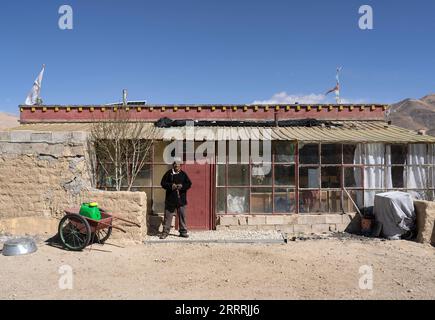 230531 -- NGARI, le 31 mai 2023 -- Losang Zhamdu pose pour des photos devant sa quatrième résidence, ou l'une des maisons de troisième génération, dans le village de Demqog, canton de Zhaxigang, comté de Gar, préfecture de Ngari, région autonome du Tibet du sud-ouest de la Chine, le 28 mai 2023. Assis au soleil devant sa résidence dans le village de Demqog, dans le canton de Zhaxigang, dans le comté de Gar dans la préfecture de Ngari au Tibet, Losang Zhamdu, 84 ans, a raconté une histoire des cinq maisons dans lesquelles il avait vécu. Ma mère et moi vivions ensemble dans une tente faite de poils de yak, tous nos biens étaient une veste de fourrure de chèvre et une couverture tibétaine usée, re Banque D'Images