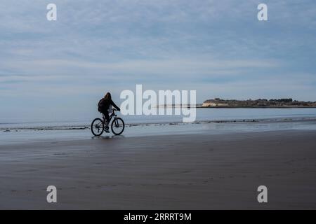 230614 -- PUERTO MADRYN, le 14 juin 2023 -- Une femme fait du vélo sur une plage de Puerto Madryn, en Argentine, le 13 juin 2023. Des milliers de baleines viennent se reproduire et vêler ici entre juin et décembre chaque année. ARGENTINE-PUERTO MADRYN-ENVIRONNEMENT-FAUNE WangxTiancong PUBLICATIONxNOTxINxCHN Banque D'Images