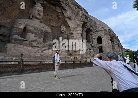 230618 -- DATONG, le 18 juin 2023 -- Un visiteur pose pour des photos aux grottes de Yungang à Datong, dans la province du Shanxi du nord de la Chine, le 7 juin 2023. Datong, avec une histoire de plus de 2 000 ans, est l'une des anciennes capitales de la Chine. Au cours des dernières années, Datong a développé son tourisme en combinant un riche patrimoine culturel et des attractions bien connues. La ville historique brille d'une nouvelle vitalité. CHINA-SHANXI-DATONG-CULTURE CN YangxChenguang PUBLICATIONxNOTxINxCHN Banque D'Images