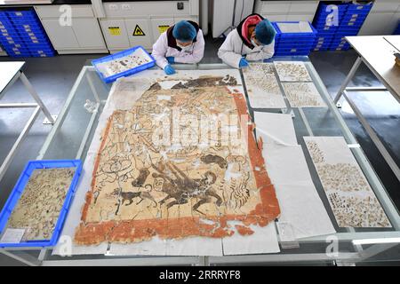 230618 -- DATONG, 18 juin 2023 -- des techniciens de l'Institut de recherche sur les grottes de Yungang restaurent un morceau de fresque dans leur atelier de Datong, dans la province du Shanxi, dans le nord de la Chine, le 9 mai 2021. Datong, avec une histoire de plus de 2 000 ans, est l'une des anciennes capitales de la Chine. Au cours des dernières années, Datong a développé son tourisme en combinant un riche patrimoine culturel et des attractions bien connues. La ville historique brille d'une nouvelle vitalité. CHINA-SHANXI-DATONG-CULTURE CN ZhanxYan PUBLICATIONxNOTxINxCHN Banque D'Images