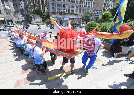 230624 -- FUZHOU, le 24 juin 2023 -- les populations locales transfèrent un bateau-dragon nouvellement construit, qui sera présenté aux habitants de Matsu en cadeau, à Lianjiang, dans la province du Fujian du sud-est de la Chine, le 31 mai 2023. Le festival des bateaux-dragons, également connu sous le nom de festival de Duanwu, tombe traditionnellement le cinquième jour du cinquième mois du calendrier lunaire chinois. La compétition de bateaux-dragons, une partie traditionnelle du festival, a gagné en popularité des deux côtés du détroit de Taiwan, suscitant l'excitation à un large éventail de personnes. Situé sur la côte sud-est de la Chine, la province du Fujian est idéal pour W Banque D'Images