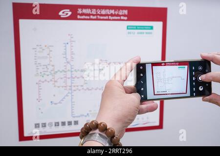 230624 -- SUZHOU, le 24 juin 2023 -- Un passager prend des photos de la carte du système de transport ferroviaire sur un train de la ligne 11 du métro de Suzhou le 24 juin 2023. Samedi, la ligne 11 du métro de Suzhou a été mise en service, reliant la ville de Suzhou, un important contributeur au PIB dans la province du Jiangsu de l est de la Chine, à Shanghai, un autre poids lourd économique de la région. C’est la première fois que les villes centrales de la région du delta du fleuve Yangtze relient leurs systèmes de métro urbains distincts, dépassant les frontières administratives et les barrières géographiques dans différentes régions provinciales. Le nouveau la Banque D'Images