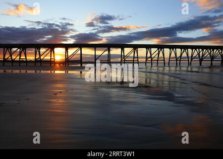 Vue sur une jetée en bois et la plage au coucher du soleil. Hartlepool, comté de Durham, Angleterre, Royaume-Uni. Banque D'Images