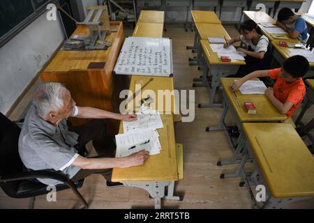 230630 -- HEXIAN, le 30 juin 2023 -- Ye Lianping donne un cours d'anglais à la maison pour enfants laissés-pour-compte dans le village de Buchen, dans le comté de Hexian, province de l'Anhui dans l'est de la Chine, le 29 juin 2023. YE Lianping, 95 ans, enseignant à la retraite, a commencé à donner des cours d'anglais gratuits en 2000 lorsqu'il a créé une maison pour les enfants laissés-pour-compte dans le village de Buchen. La plupart de ses élèves sont laissés dans le village car leurs parents sont allés travailler dans les villes. Au cours des 23 dernières années, plus de 2 000 enfants ont bénéficié de cours de Ye s. YE Lianping, vivant une vie simple sans enfants, dépense la plupart de ses économies à gérer le Ye Banque D'Images