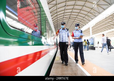 230701 -- XINING, le 1 juillet 2023 -- deux agents de la police des chemins de fer effectuent un contrôle de sécurité avant le départ du train à grande vitesse Fuxing C891 sur la section Xining-Golmud du chemin de fer Qinghai-Tibet à Xining, dans la province du Qinghai au nord-ouest de la Chine, le 1 juillet 2023. Les trains à grande vitesse Fuxing ont officiellement commencé à fonctionner sur la section Xining-Golmud du chemin de fer Qinghai-Tibet samedi. Avec une longueur opérationnelle totale de 829 km, il commence à Xining, capitale de la province du Qinghai du nord-ouest de la Chine, à l est et passe par Huangyuan, Haiyan, Ulan, Delingha à la gare de Golmud à l ouest, selon Banque D'Images