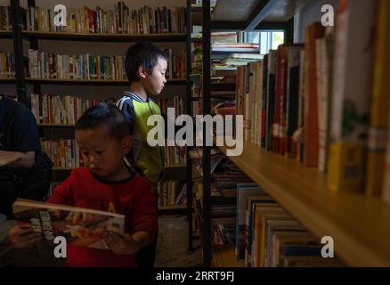 230707 -- GONGSHAN, le 7 juillet 2023 -- Un enfant choisit des livres à la bibliothèque de Banshan Huayu dans le village de Qiunatong, dans le canton de Bingzhongluo, dans le comté autonome de Gongshan Dulong et nu, préfecture autonome de Lisu de Nujiang, province du Yunnan au sud-ouest de la Chine, le 5 juillet 2023. La rivière Nujiang, descendant des montagnes Tanggula sur le plateau Qinghai-Tibet, se fraie un chemin à travers les majestueuses montagnes du Yunnan où se forme un magnifique canyon. Niché à la pointe nord du canyon de la rivière Nujiang se trouve le village de Qiunatong, qui abrite une bibliothèque unique appelée Banshan Huayu Half Hill Flo Banque D'Images