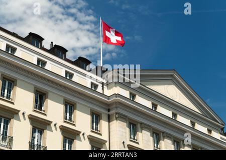 Genève, suisse. Août 13. 2023. Le drapeau national suisse flotte dans le vent sur un bâtiment du quartier du lac Léman. Banque D'Images