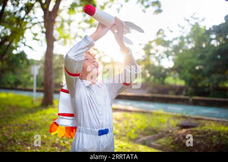 Petit garçon jouant avec vaisseau spatial. Costume d'astronaute pour Halloween. Enfant créatif avec fusée spatiale. Les enfants rêvent et imaginent. Banque D'Images