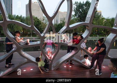 230713 -- BEIJING, le 13 juillet 2023 -- les gens s'amusent au bord de la rivière Liangma à Beijing, capitale de la Chine, le 25 juin 2023. La Seine, deuxième plus grande rivière de France, serpente au cœur de Paris. S'écoulant d'ouest en est, il divise la ville en l'emblématique rive gauche et rive droite. La rive gauche est définie par une ambiance artistique, ornée de cafés, théâtres et librairies, créant un havre pour le cercle littéraire et un paradis culturel. D'autre part, la rive droite abrite des monuments prestigieux tels que le Louvre, l'ancien palais royal, et l'Elysée, le curre Banque D'Images