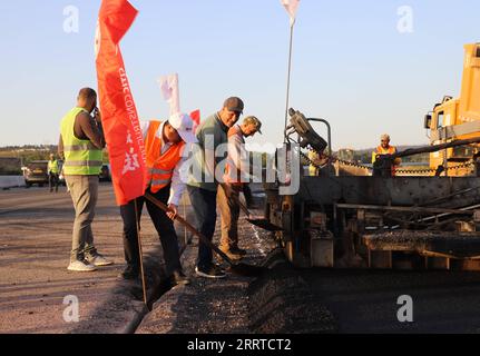 230717 -- El TARFALGERIA, 17 juillet 2023 -- cette photo prise le 5 juillet 2023 montre Qi Shujie, directeur général adjoint de CITIC Construction Algérie, et Mohamed Salah Kafi, chef du bureau de la région est de l Agence nationale des autoroutes algériennes, pavant ensemble le dernier mètre de l autoroute est-Ouest avec de l asphalte dans la province d El Tarf, en Algérie. POUR ALLER AVEC la caractéristique : un entrepreneur chinois brave la chaleur pour terminer le tronçon final du projet d autoroute algérien photo fournie par CITIC Construction/document via Xinhua ALGERIA-El TARF-CHINESE COMPANY-EAST-WEST HIGHWAY CONSTRUCTION WuxTianyu PUBLICATIONxNOT Banque D'Images