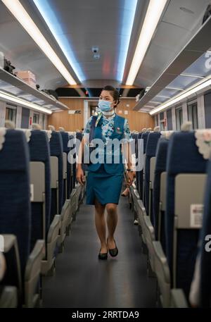 230718 -- MENGLA, le 18 juillet 2023 -- Yi Bofeng inspecte un wagon à bord du train D887 le 16 juillet 2023. Yi Bofeng est originaire du comté de Mengla dans la province du Yunnan. Après avoir obtenu son diplôme de major laotien dans un collège technique de la capitale provinciale Kunming en 2020, elle a été recrutée comme hôtesse de train dans China Railway Kunming Bureau Group Co., Ltd Le chemin de fer Chine-Laos, un projet historique de coopération de haute qualité ceinture et route, a commencé ses opérations en décembre 2021. Yi était à bord du premier train du chemin de fer, témoin du moment historique de l'exploitation ferroviaire. La connexion ferroviaire de 1 035 km Banque D'Images