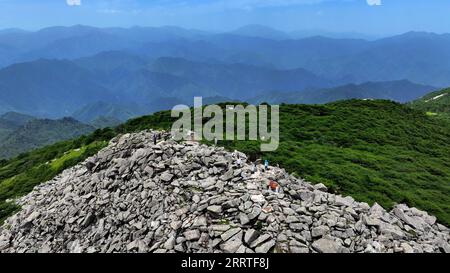 230722 -- XI AN, le 22 juillet 2023 -- cette photo aérienne prise le 21 juillet 2023 montre des visiteurs atteignant le pic de Bingjing, le point culminant du parc forestier national de Zhuque à Xi an, dans la province du Shaanxi, au nord-ouest de la Chine. Le parc, situé dans le cours supérieur de la rivière Laohe est et dans le nord des montagnes Qinling, couvre une superficie de 2 621 hectares, et son point culminant Bingjing pic a une altitude de 3 015 mètres. Des paysages étonnants tels que la forêt vierge, les restes de glaciers et la mer de nuages peuvent être vus le long de la route vers le sommet. CHINA-SHAANXI-ZHUQUE NATIONAL PARK-SCENERY CN LIUXXIAO PUBLICATIONXN Banque D'Images