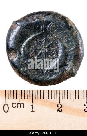 Pièce de cuivre de drachme grecque antique avec l'image de Dionysos I et deux dauphins. Marche arrière. Isolé sur blanc Banque D'Images