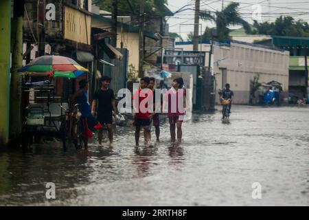 230726 -- VILLE de MALABON, 26 juillet 2023 -- des gens se promenaient dans une zone gorgée d'eau à Malabon City, aux Philippines, le 26 juillet 2023. L'agence nationale de lutte contre les catastrophes des Philippines a déclaré mercredi qu'elle avait jusqu'à présent dénombré au moins un mort alors que le typhon Doksuri continuait de frapper le pays avec de la pluie et des vents forts. Doksuri a touché huit régions à travers l'île de Luzon et le centre des Philippines. Près de 9 000 résidents déplacés séjournent dans 107 centres d’évacuation, a ajouté le Conseil national de gestion et de réduction des risques de catastrophe. PHILIPPINES-MALABON VILLE-TYPHON DOKSURI ROUELLEXUMALI PUBLIC Banque D'Images