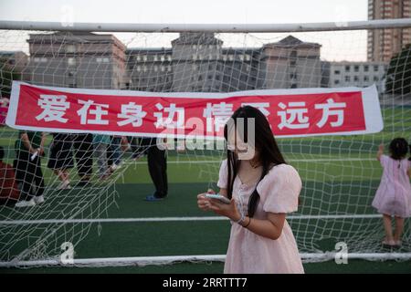 230810 -- WUCHANG, 10 août 2023 -- Une femme utilise son téléphone portable dans un refuge temporaire de l'école secondaire Shidai à Wuchang, dans la province du Heilongjiang, dans le nord-est de la Chine, le 9 août 2023. La ville de Wuchang a été gravement touchée par les inondations provoquées par la pluie. Au total, 2 498 résidents évacués se réfugient dans deux collèges. CHINE-HEILONGJIANG-WUCHANG-INONDATION-ABRI TEMPORAIRE CN ZHANGXTAO PUBLICATIONXNOTXINXCHN Banque D'Images