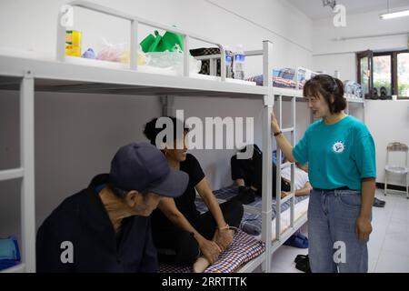 230810 -- WUCHANG, 10 août 2023 -- Zhang Xiaohong R, membre du personnel, discute avec des résidents d'un refuge temporaire dans le collège Shidai à Wuchang, dans la province du Heilongjiang, dans le nord-est de la Chine, le 10 août 2023. La ville de Wuchang a été gravement touchée par les inondations provoquées par la pluie. Au total, 2 498 résidents évacués se réfugient dans deux collèges. CHINE-HEILONGJIANG-WUCHANG-INONDATION-ABRI TEMPORAIRE CN ZHANGXTAO PUBLICATIONXNOTXINXCHN Banque D'Images