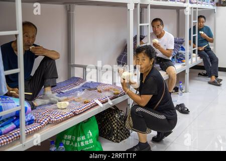 230810 -- WUCHANG, 10 août 2023 -- des gens dînent dans un refuge temporaire à l'école secondaire Shidai à Wuchang, dans la province du Heilongjiang, dans le nord-est de la Chine, le 9 août 2023. La ville de Wuchang a été gravement touchée par les inondations provoquées par la pluie. Au total, 2 498 résidents évacués se réfugient dans deux collèges. CHINE-HEILONGJIANG-WUCHANG-INONDATION-ABRI TEMPORAIRE CN ZHANGXTAO PUBLICATIONXNOTXINXCHN Banque D'Images