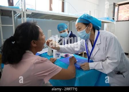 230810 -- WUCHANG, le 10 août 2023 -- Un médecin examine un résident d'un refuge temporaire à l'école secondaire Shidai à Wuchang, dans la province du Heilongjiang du nord-est de la Chine, le 9 août 2023. La ville de Wuchang a été gravement touchée par les inondations provoquées par la pluie. Au total, 2 498 résidents évacués se réfugient dans deux collèges. CHINE-HEILONGJIANG-WUCHANG-INONDATION-ABRI TEMPORAIRE CN ZHANGXTAO PUBLICATIONXNOTXINXCHN Banque D'Images