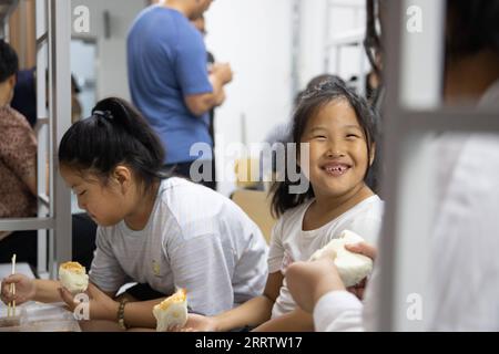 230810 -- WUCHANG, 10 août 2023 -- des gens dînent dans un refuge temporaire à l'école secondaire Shidai à Wuchang, dans la province du Heilongjiang, dans le nord-est de la Chine, le 9 août 2023. La ville de Wuchang a été gravement touchée par les inondations provoquées par la pluie. Au total, 2 498 résidents évacués se réfugient dans deux collèges. CHINE-HEILONGJIANG-WUCHANG-INONDATION-ABRI TEMPORAIRE CN ZHANGXTAO PUBLICATIONXNOTXINXCHN Banque D'Images