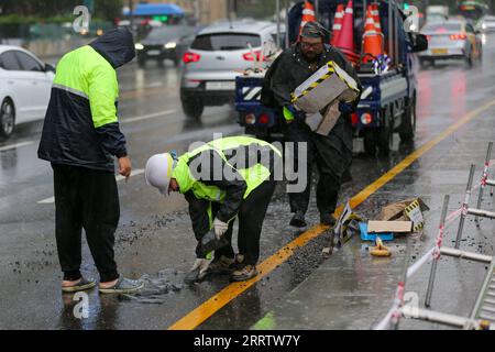 230810 -- SÉOUL, le 10 août 2023 -- des ouvriers réparent une surface de rue sous la pluie apportée par le typhon Khanun à Séoul, Corée du Sud, le 10 août 2023. Le typhon Khanun a apporté un vent puissant et de fortes pluies dans certaines parties de la Corée du Sud. CORÉE DU SUD-SÉOUL-TYPHON KHANUN-FORTES PRÉCIPITATIONS WANGXYILIANG PUBLICATIONXNOTXINXCHN Banque D'Images