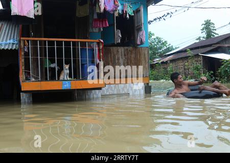 230812 -- BAGO, 12 août 2023 -- Un homme est assis sur un tube flottant dans les eaux de crue à Bago, Myanmar, le 12 août 2023. Le Département de la gestion des catastrophes du Myanmar a déclaré vendredi que plus de 45 000 personnes se trouvaient actuellement dans les abris anti-inondations à travers le pays en raison des inondations provoquées par la montée du niveau des rivières et les pluies intenses ces derniers jours. POUR ALLER AVEC Roundup : plus de 45 000 000 déplacés par inondations, glissements de terrain ont frappé Myanmar photo par /Xinhua MYANMAR-BAGO-FLOOD MyoxKyawxSoe PUBLICATIONxNOTxINxCHN Banque D'Images