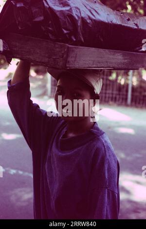 Femme balinaise locale portant un panier sur sa tête sur son chemin pour vendre au marché d'Ubud Banque D'Images