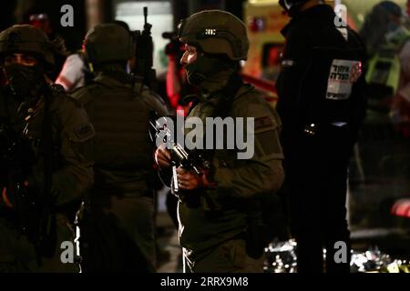 230830 -- JÉRUSALEM, 30 août 2023 -- les forces de sécurité israéliennes montent la garde sur le site d'une attaque au couteau à un arrêt de tramway près de Jérusalem-est, le 30 août 2023. Un palestinien déguisé en juif ultra-orthodoxe a poignardé un israélien mercredi à Jérusalem avant d’être abattu par la police israélienne. Photo de /Xinhua MIDEAST-JERUSALEM-KNIFE ATTACK MuammarxAwad PUBLICATIONxNOTxINxCHN Banque D'Images