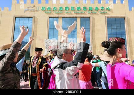 230906 -- TAXKORGAN, le 6 septembre 2023 -- des membres d'un ensemble de chant et de danse local dansent avec des touristes devant le centre de service à la clientèle de la zone touristique de Pamir dans le comté autonome tadjik de Taxkorgan, région autonome ouïgour du Xinjiang, au nord-ouest de la Chine, le 4 septembre 2023. Taxkorgan, un comté frontalier qui ne compte pas plus de 50 000 habitants, est réputé pour ses attractions touristiques, et il a reçu plus de 900 000 touristes au cours des huit premiers mois de l'année. CHINA-XINJIANG-TAXKORGAN-TOURIST SERVICE CN LANXHONGGUANG PUBLICATIONXNOTXINXCHN Banque D'Images