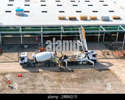 Pontyclun, pays de Galles - 7 septembre 2023 : vue drone du béton pompé d'un mélangeur pour le plancher d'un nouveau supermarché pour Sainsbury's. Banque D'Images