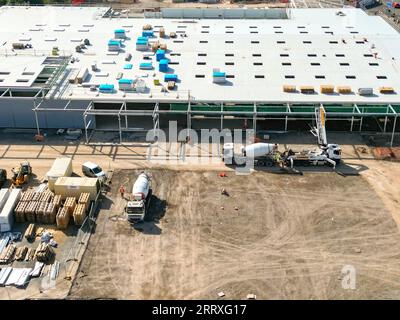 Pontyclun, pays de Galles - 7 septembre 2023 : vue drone du béton pompé d'un mélangeur pour le plancher d'un nouveau supermarché pour Sainsbury's. Banque D'Images