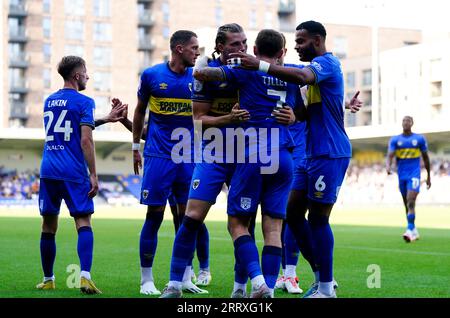 Joshua Davison de l'AFC Wimbledon (troisième à gauche) est félicité par ses coéquipiers après avoir marqué le premier but de son équipe lors du match de Sky Bet League Two au Cherry Red Records Stadium, à Londres. Date de la photo : Samedi 9 septembre 2023. Banque D'Images