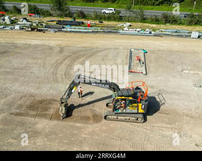 Pontyclun, pays de Galles - 7 septembre 2023 : vue par drone d'une excavatrice grattant le sol pour préparer le parking d'un nouveau supermarché dans le sud du pays de Galles Banque D'Images