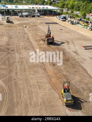 Pontyclun, pays de Galles - 7 septembre 2023 : vue par drone d'une excavatrice et d'une machine à rouleaux préparant le parking d'un nouveau supermarché dans le sud du pays de Galles Banque D'Images