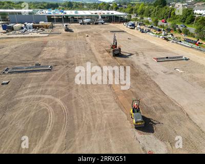 Pontyclun, pays de Galles - 7 septembre 2023 : vue par drone d'une excavatrice et d'une machine à rouleaux préparant le parking d'un nouveau supermarché dans le sud du pays de Galles Banque D'Images