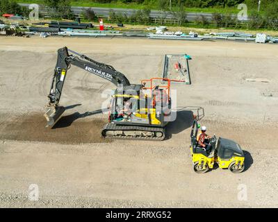 Pontyclun, pays de Galles - 7 septembre 2023 : vue par drone d'une excavatrice et d'une machine à rouleaux préparant le parking d'un nouveau supermarché dans le sud du pays de Galles Banque D'Images