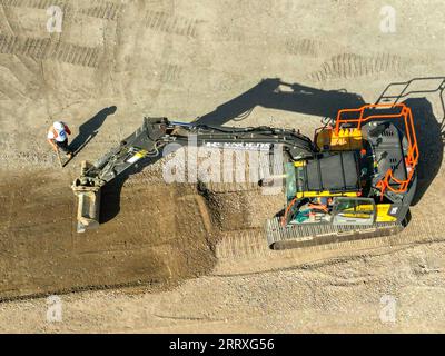 Pontyclun, pays de Galles - 7 septembre 2023 : vue par drone d'une excavatrice grattant le sol pour préparer le parking d'un nouveau supermarché dans le sud du pays de Galles Banque D'Images