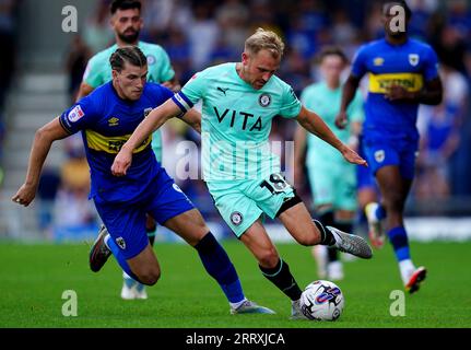 Joshua Davison de l'AFC Wimbledon (à gauche) et Ryan Croasdale du comté de Stockport se battent pour le ballon lors du match de Sky Bet League Two au Cherry Red Records Stadium, à Londres. Date de la photo : Samedi 9 septembre 2023. Banque D'Images