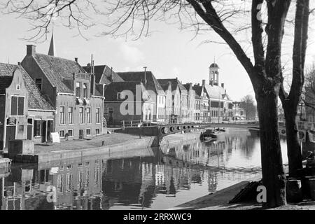 Blick über eine Gracht auf das Stadthaus von Dokkum, Niederlande 1941. Vue sur un canal à la maison de ville de Dokkum, pays-Bas 1941. Banque D'Images