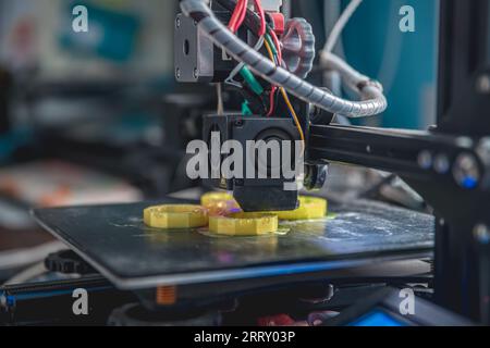 Imprimante 3D imprime un modèle en plastique jaune Banque D'Images